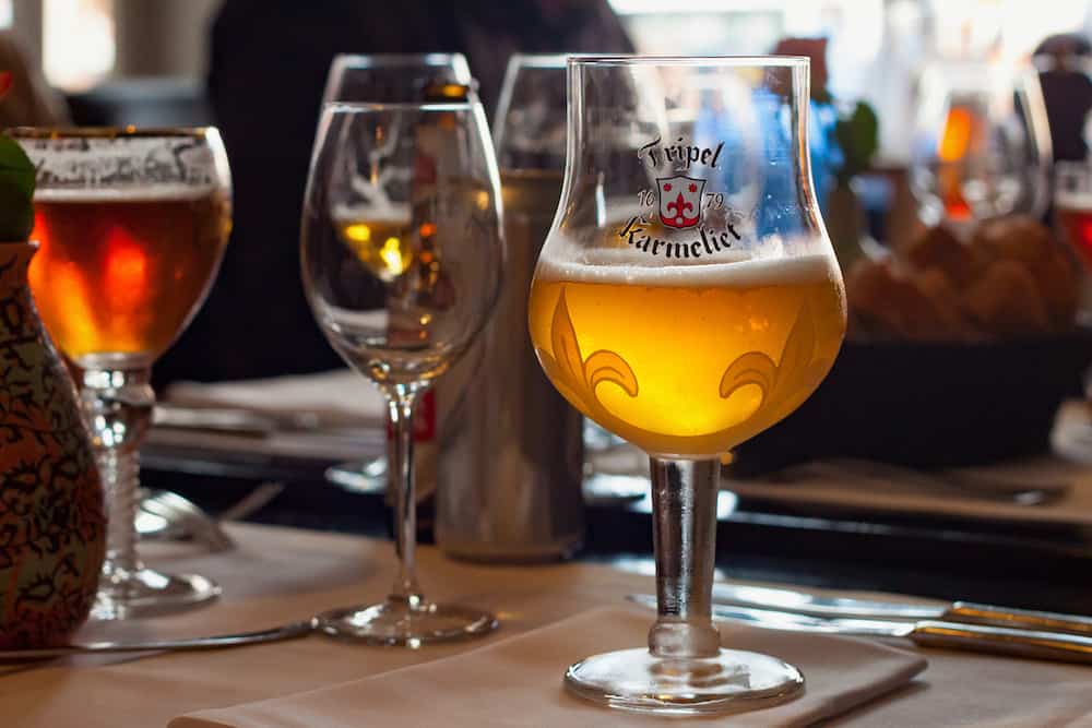 LEUVEN, BELGIUM - Original glass of Tripel Karmeliet beer in one of the restaurants in the Leuven. Is a golden Belgian beer with high alcohol by volume brewed by Brouwerij Bosteels