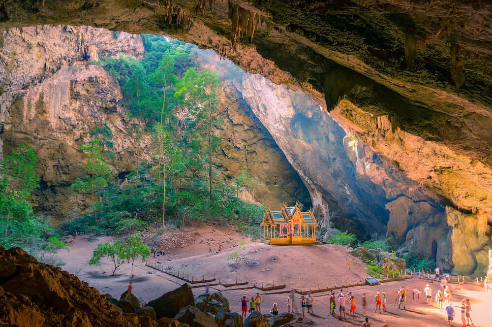 Buddhist temple in the cave with unidentifiable tourists around. Khuha Kharuehat Pavilion in Phraya Nakhon Cave in Kui Buri, Thailand