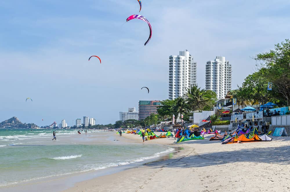 Hua hin, Thailand - View at Hua hin town, a coastal city near Bangkok on the Gulf of Thailand, and its beach front with kites flying, hotel buildings and the Chopsticks Hill Khao Takiap, known locally as Monkey Mountain to the left