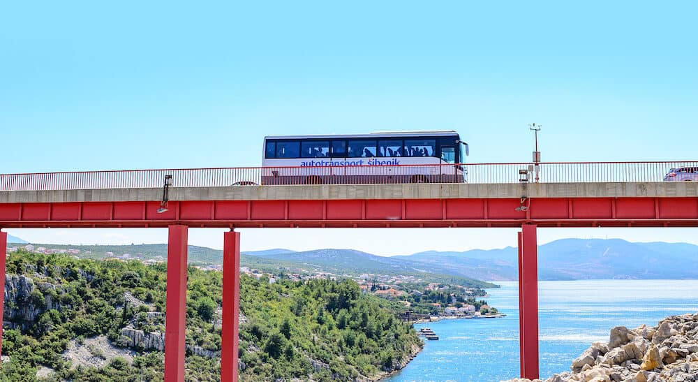 ZADAR, CROATIA - Bus rides over the bridge located above the sea bay on a summer day, near Zadar, Croatia.