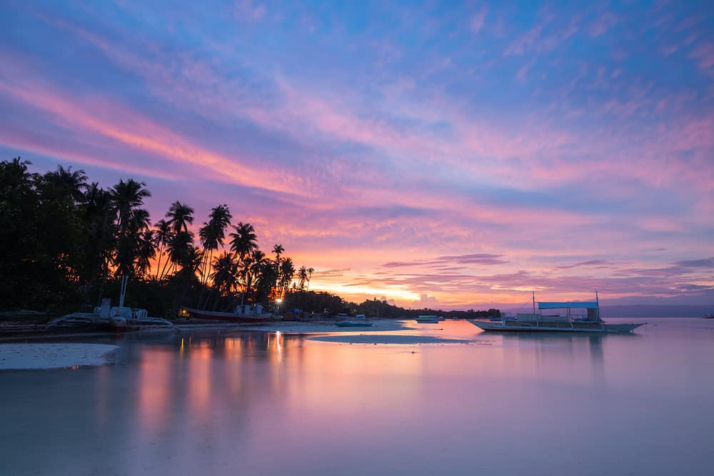 Sunset view of the Dolho Beach with traditional bangka boats, Panglao, Bohol, Philippines