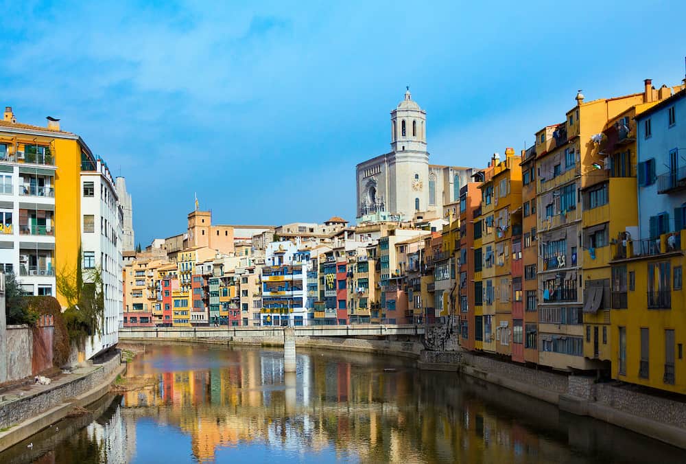 Girona, Spain - Colorful and houses and bridge Pont de Sant Agusti reflected in river Onyar, in Girona, Catalonia, Spain. Saint Mary Cathedral at background in winter