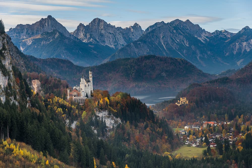 View of Neuschwanstein castle and Hohenschwangau castle from cable car to the top of Tegelberg with mountain view in autumn as background