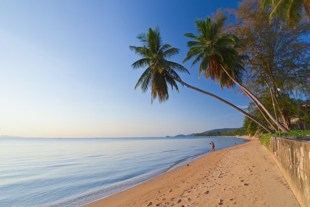 young couple relax and take pictures on the beach on Koh Samui in Thailand, travel and enjoy paradise, many palm trees and coconuts, lovers on the lipa noi beach